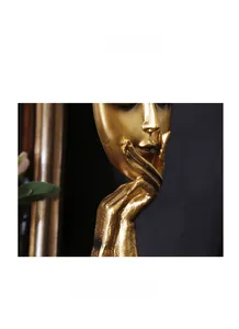 Gedetailleerde macro-opname van de gladde gouden lak op een abstract gezichtsbeeldhouwwerk