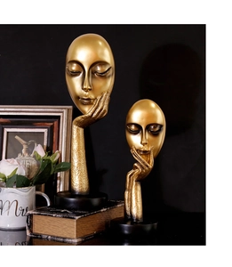 Close-up of golden resin abstract face sculptures as artistic ornaments for home and office