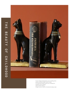 Decorative resin Egyptian Bastet cat bookends holding a vintage book for home decor