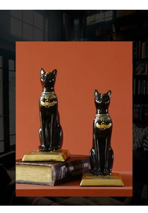 Macro detail of Egyptian Bastet cat bookends with golden scarab details and black finish