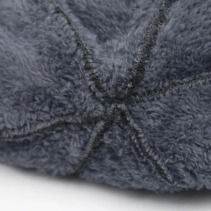 Macro shot of thick coral fleece lining and precise stitching on warm winter beanie