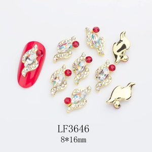 Macro detail of LF3646 gold alloy nail charms with marquise rhinestones and red accents