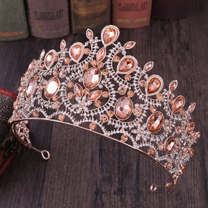 Elegant rose gold Baroque crown with champagne rhinestones on a vintage wooden table