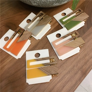 Colorful geometric wooden and acrylic triangle hair clips on a white display card