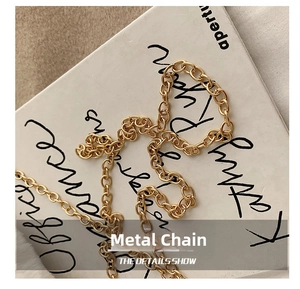 Close-up of golden metal chain with high-gloss O-link structure on white background