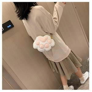Detailed view of the white plush cat paw crossbody bag with pink pads and gold chain