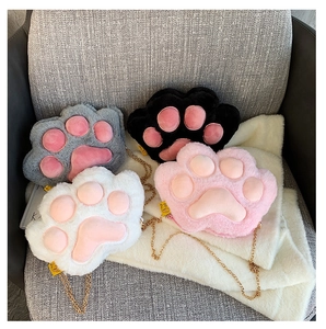 Detail view of plush cat paw bags in pink white black and grey with gold chains