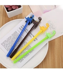 Close-up of colorful dinosaur neutral pens in blue, brown, yellow, and green on a book