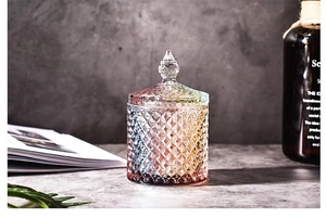 Detailed view of large iridescent glass storage jar with diamond cut patterns and matching lid