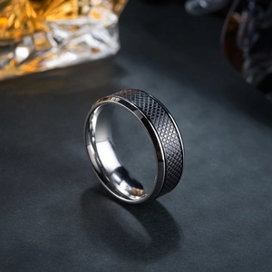 Men's two-tone stainless steel ring with black mesh texture on dark textured background