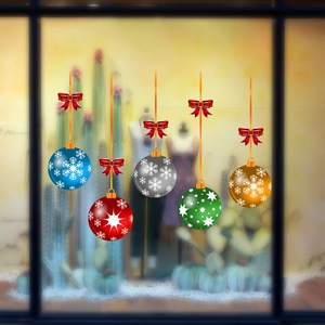 Close-up of colorful Christmas ball window stickers with red bows and snowflake motifs