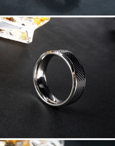 Detailed shot of black knurled men's ring with silver polished interior on dark surface