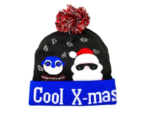 Detail of a black and blue knit beanie featuring Cool X-mas text and Santa graphic