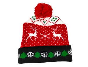 Detail of knitted Christmas hat with pompom featuring reindeer and snowflake patterns
