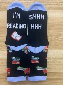 Funny cotton socks with I'M READING text and book patterns on a wooden surface