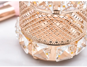 Makroaufnahme von roségoldenem Kristall-Pinselhalter mit facettierten Glasperlen und Metallfüßen