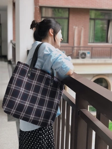 Deep blue British plaid oversized canvas tote bag shown on model in street scene