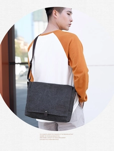 Model wearing a casual dark grey canvas messenger bag, showing back and side profile