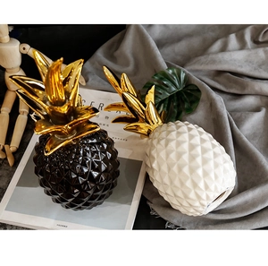 Close-up of luxury ceramic pineapple decor with gold electroplated leaves and lattice texture