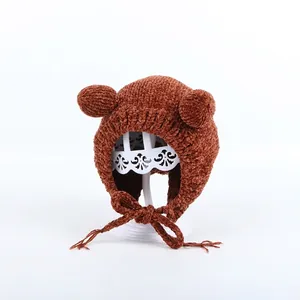 Detailed close-up of brown chenille knit baby earflap hat with cute bear ears and straps