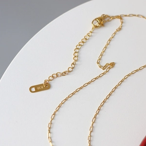 Macro view of 18K gold plated lobster clasp and chain with K18 purity hallmark