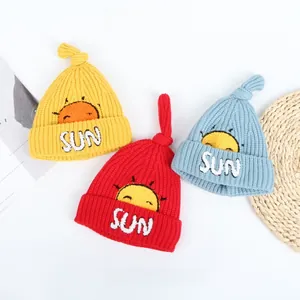 Detailed knit texture and sun embroidery on soft winter beanies for kids in three colors