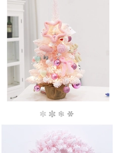 Pink Christmas tree with warm LED lights and plush heart ornaments on white desk