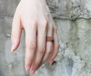 Close-up of a camo pattern silicone ring for men on a finger with natural lighting