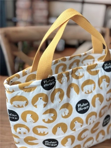 Gros plan du sac à lunch isotherme en toile avec motif ours polaire et anses jaunes