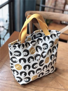 Détail du sac à déjeuner en toile avec imprimé ours polaire et anses jaunes