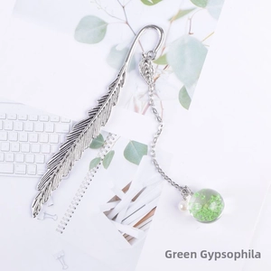 Detail of silver feather bookmark with a glass bulb containing green dried flowers