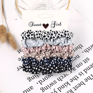 Set of six polka dot fabric scrunchies in assorted colors on a display card