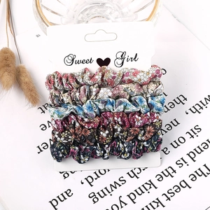 Detail of 6-piece floral fabric scrunchie set displayed on a Sweet Girl card packaging