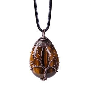 Close-up of handmade tiger eye stone pendant with bronze tree of life wire wrapping
