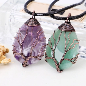 Detail of handmade copper wire tree of life pendants with amethyst and aventurine stone