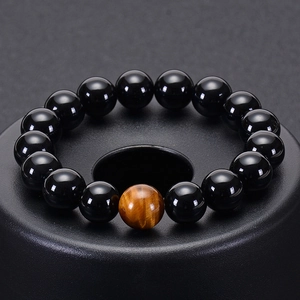 Macro detail of natural black agate beads and brown tiger eye stone on a beaded bracelet