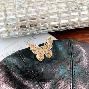 Luxurious gold butterfly open ring featuring sparkling marquise zircon on a quilted background
