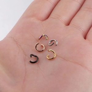 Close-up of five colorful stainless steel open rings held in palm for DIY jewelry making