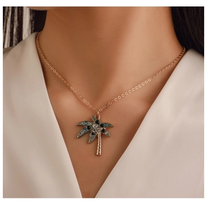 Dettaglio di una collana d'oro con un ciondolo a forma di palma con cristalli blu