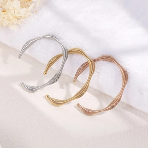 Three spiral titanium steel open bangles in silver, gold and rose gold on white fur background