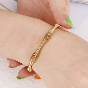 Chic rose gold spiral spring bracelet in stainless steel shown worn on a female wrist