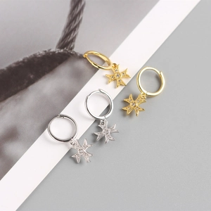 Detail view of gold and silver S925 sterling silver cross earrings with sparkling stones