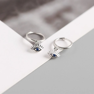 Detail of 925 sterling silver evil eye earrings with blue zircon and eyelash design
