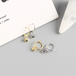 Detailed view of evil eye charms with blue zircons on gold and silver earrings