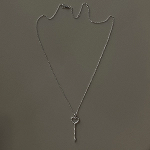 Detailed view of 925 sterling silver heart key pendant with intricate vine texture