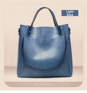 Detailed view of light blue soft leather bucket bag with fine texture and metal hooks