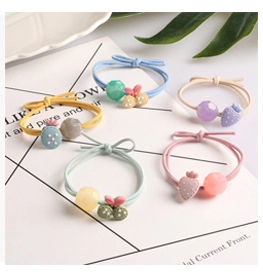 Detailed view of colorful fruit scrunchies with cute strawberry and pineapple charms