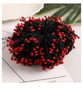 Detail of high-elasticity black hair ties set with vibrant red bead accents on white cards