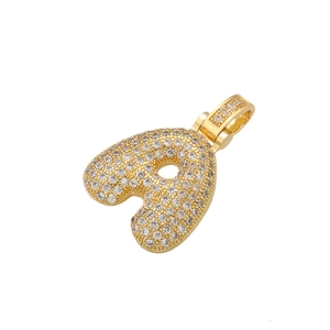 Macro view of gold bubble letter 'a' pendant with handset shimmering cubic zirconia