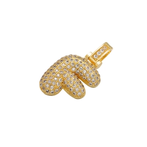Macro detail of gold-plated puffy letter pendant encrusted with clear cubic zirconia stones